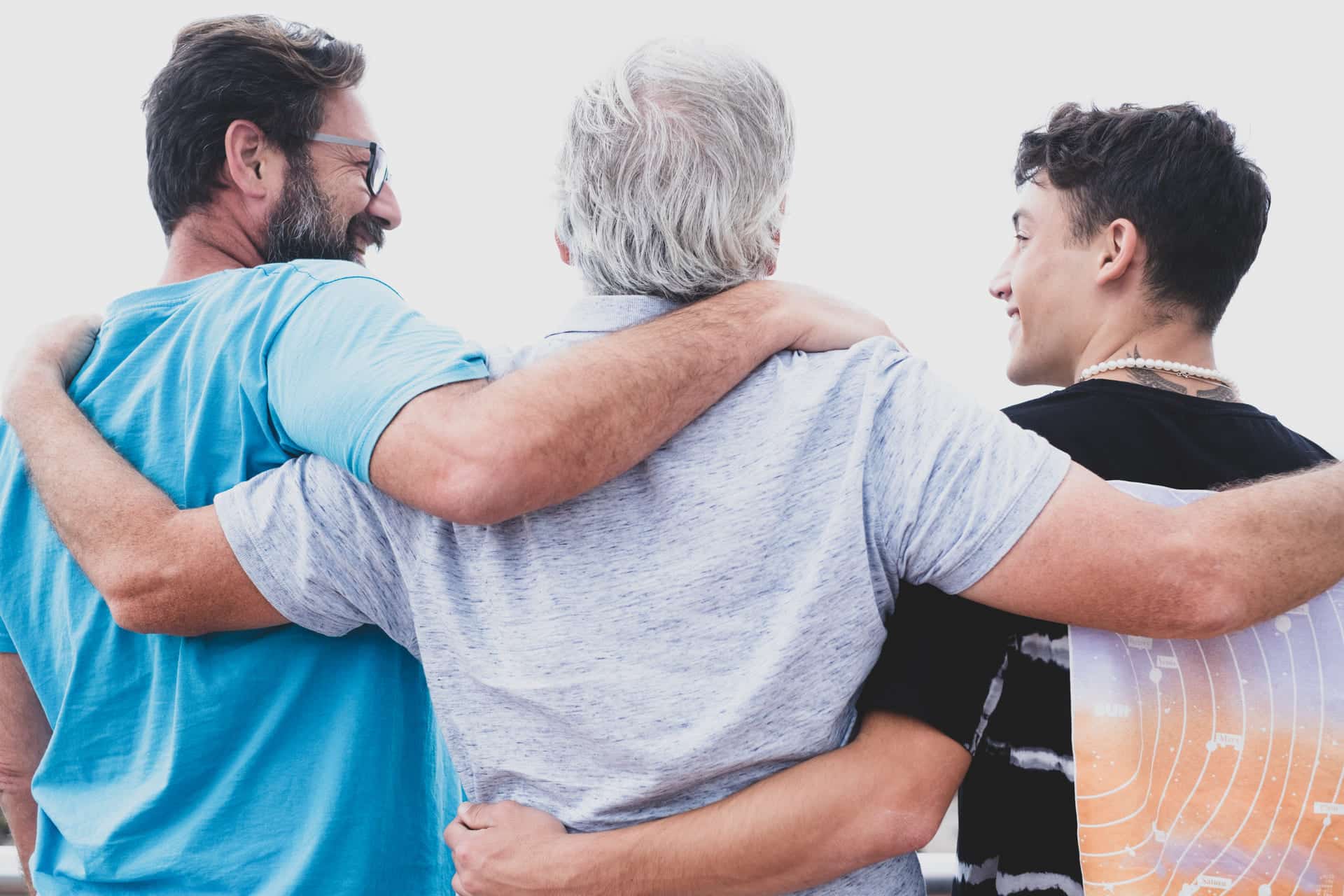 Drei Generationen Männer umarmen sich